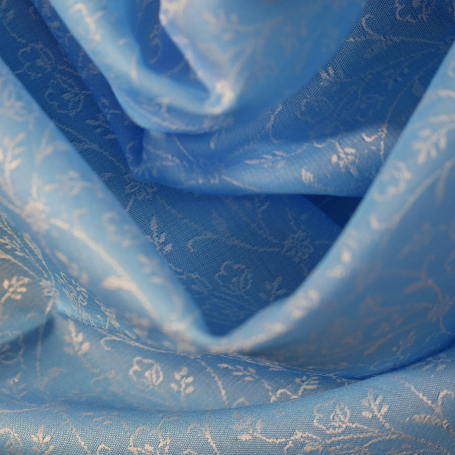 Close-up of blue fabric with white floral patterns