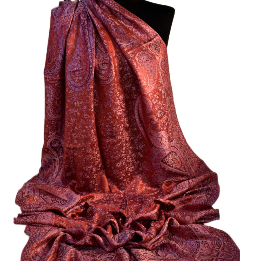 Red paisley patterned silk scarf on a black mannequin against a white background