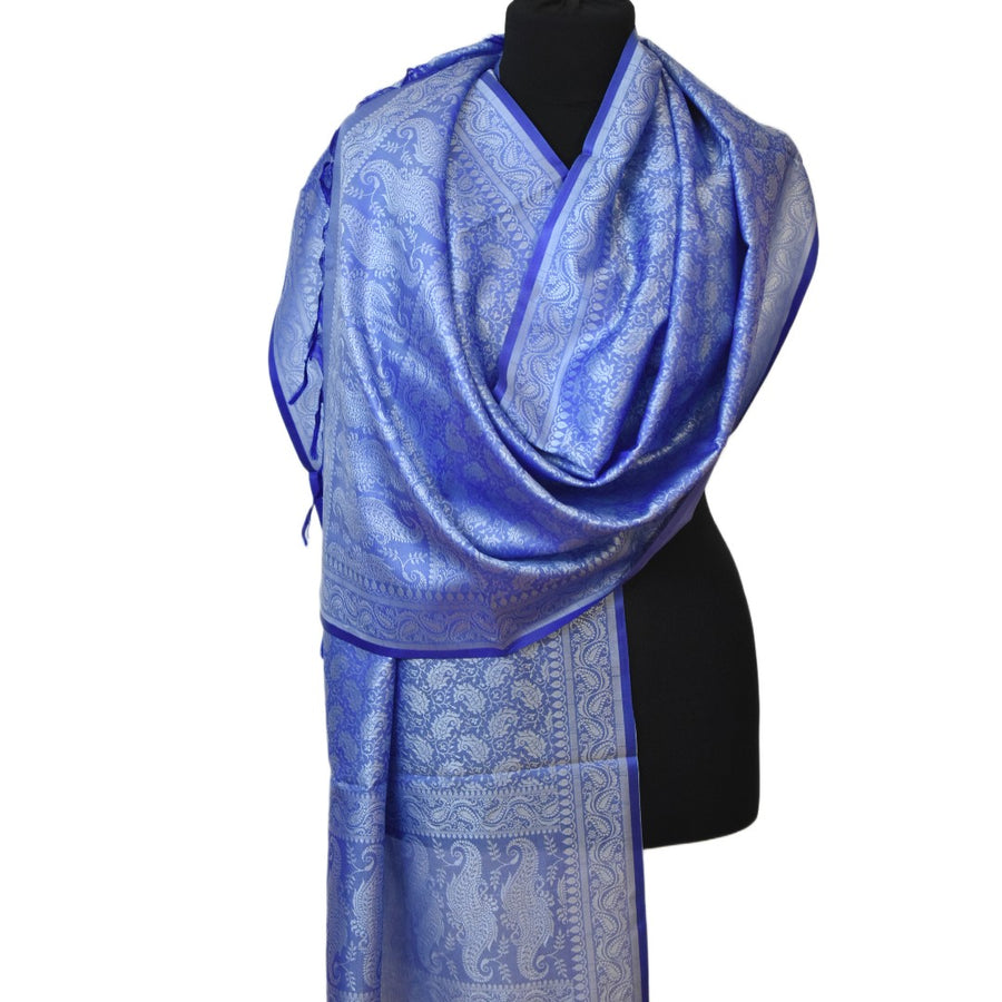 Green patterned scarf on a black mannequin against a white background