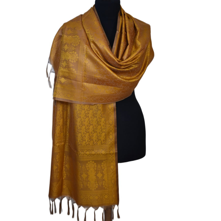 Brown scarf with intricate patterns draped over a black mannequin on a white background