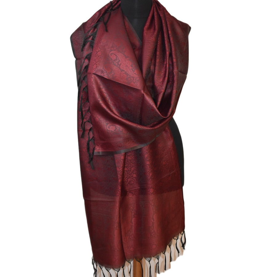 Red scarf with black patterns on a mannequin against a white background
