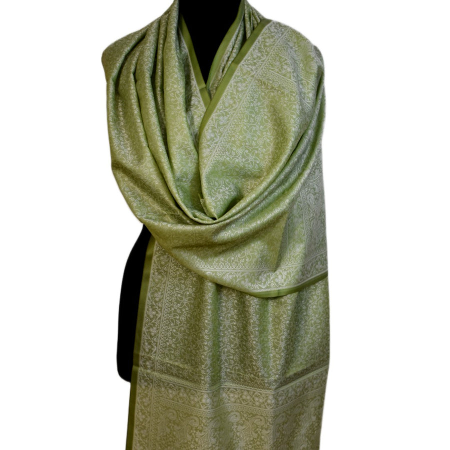 Green patterned scarf on a mannequin against a white background