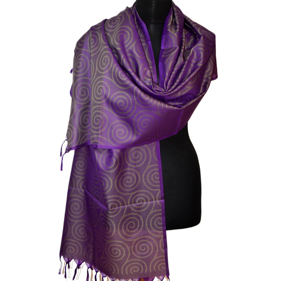 Purple scarf with a pattern draped over a black mannequin on a white background
