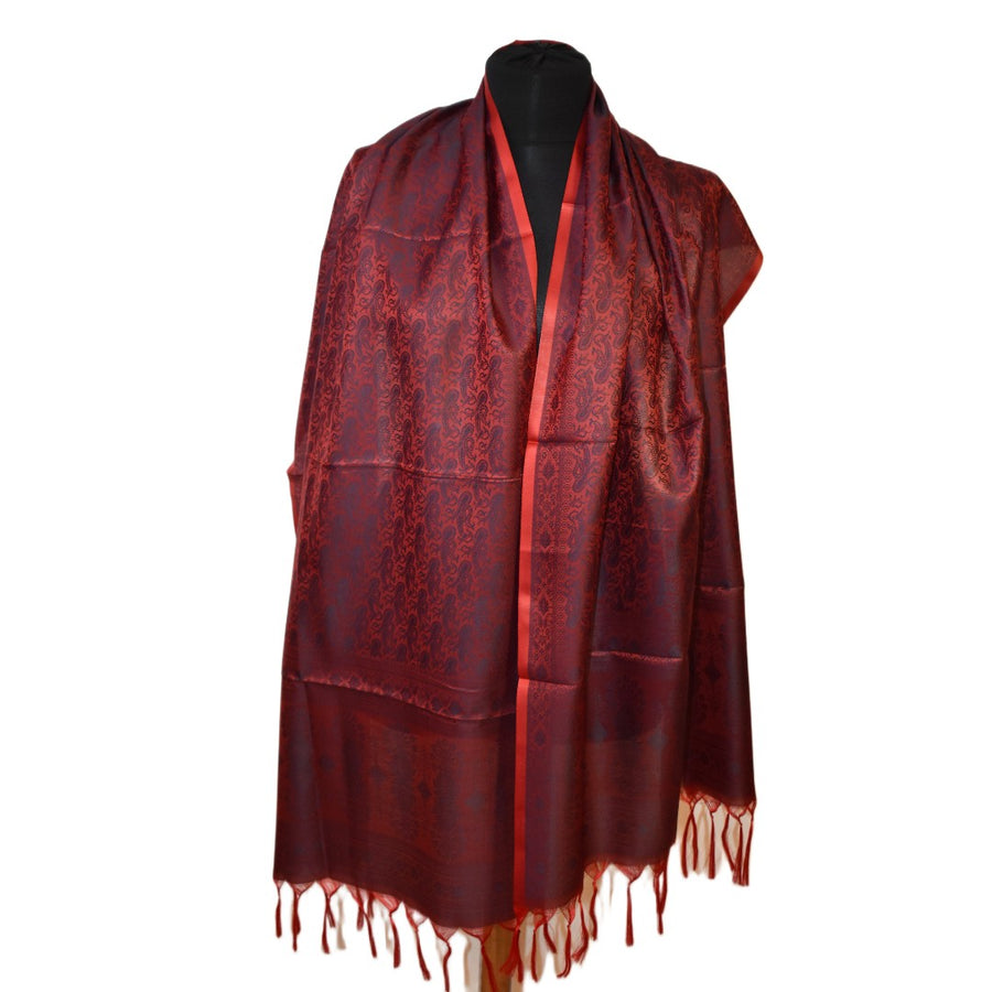 Red scarf with intricate patterns on a mannequin against a white background