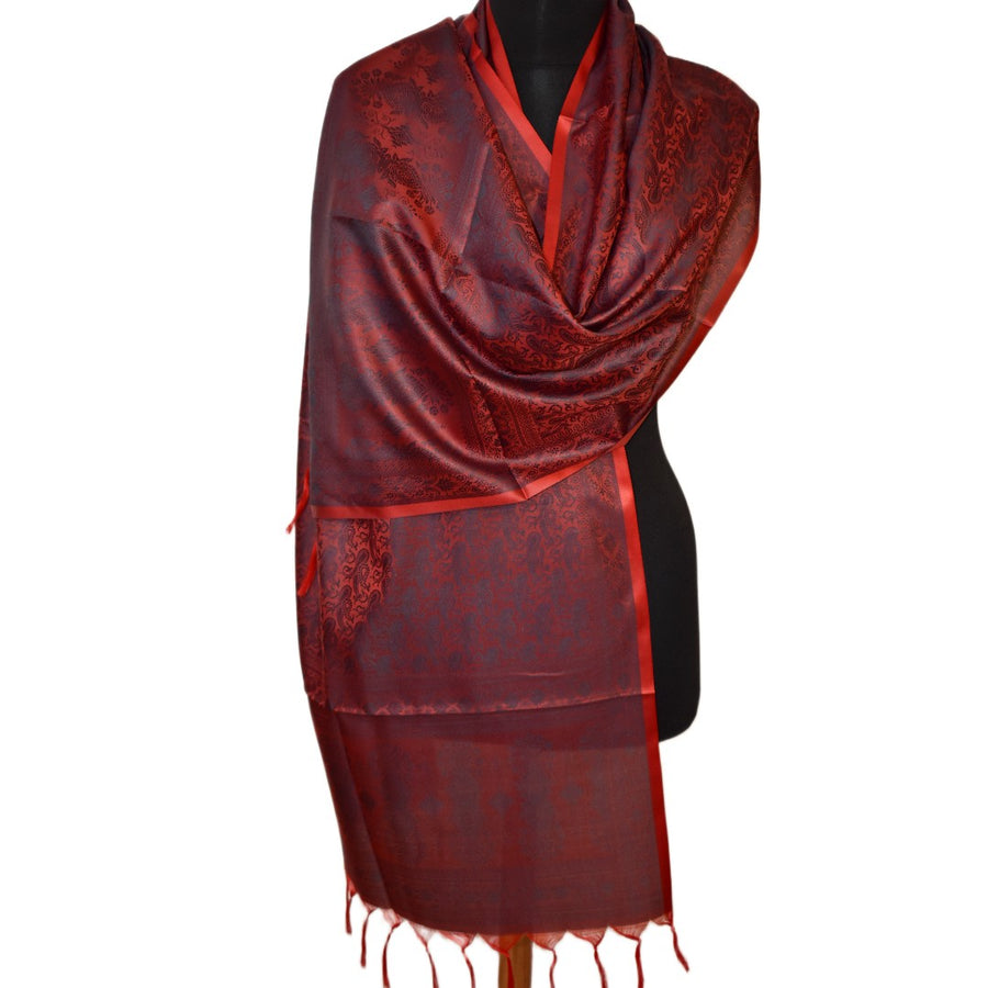 Red patterned scarf on a black mannequin against a white background