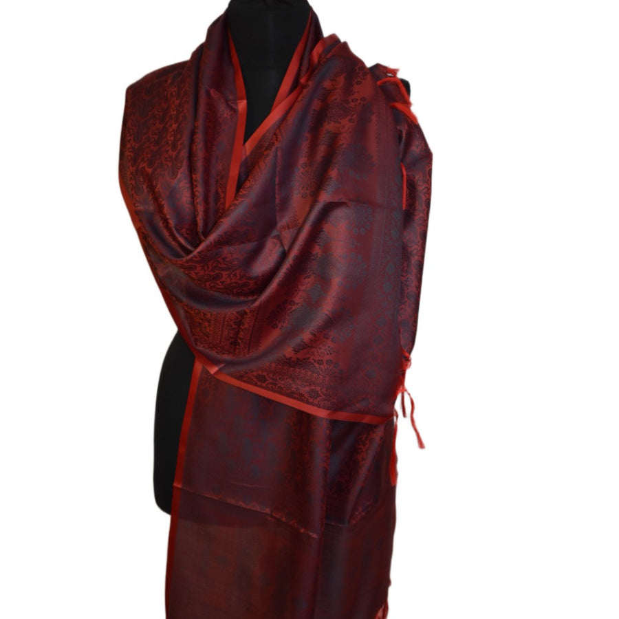Red and black patterned scarf on a mannequin against a white background