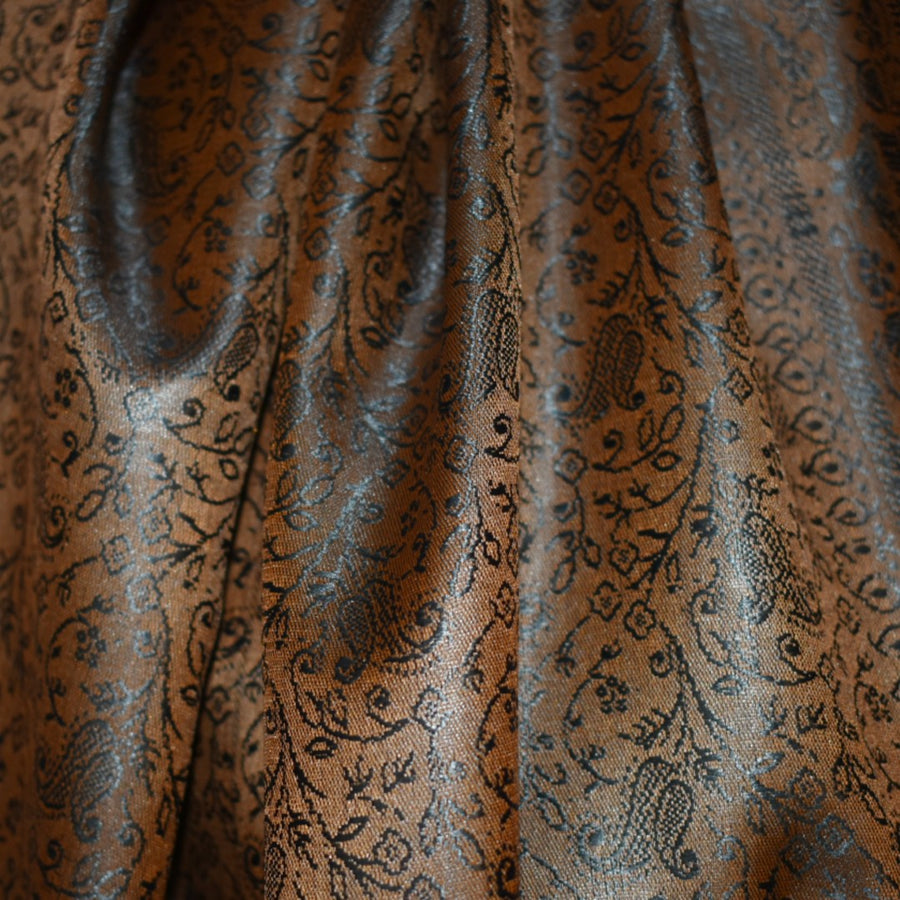 Close-up of brown fabric with intricate black floral pattern
